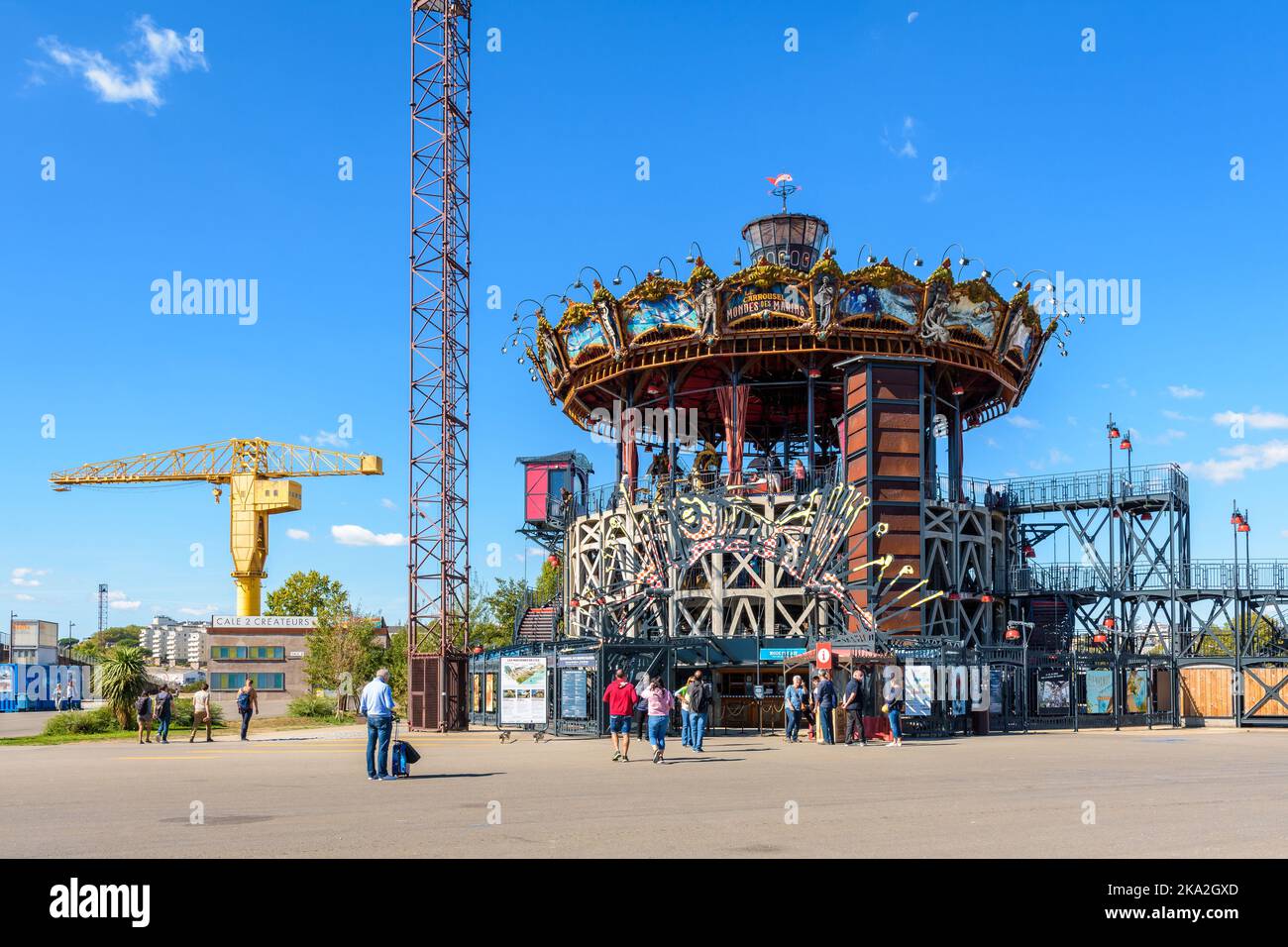 The Marine Worlds Carousel is part of the Machines of the Isle of Nantes tourist attraction, with the yellow Titan crane in the distance. Stock Photo