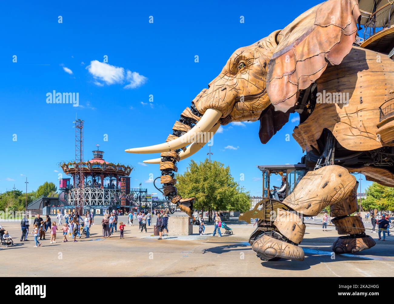 The Great Elephant giant puppet, part of the Machines of the Isle of Nantes attraction, with the Marine Worlds Carousel in the distance. Stock Photo