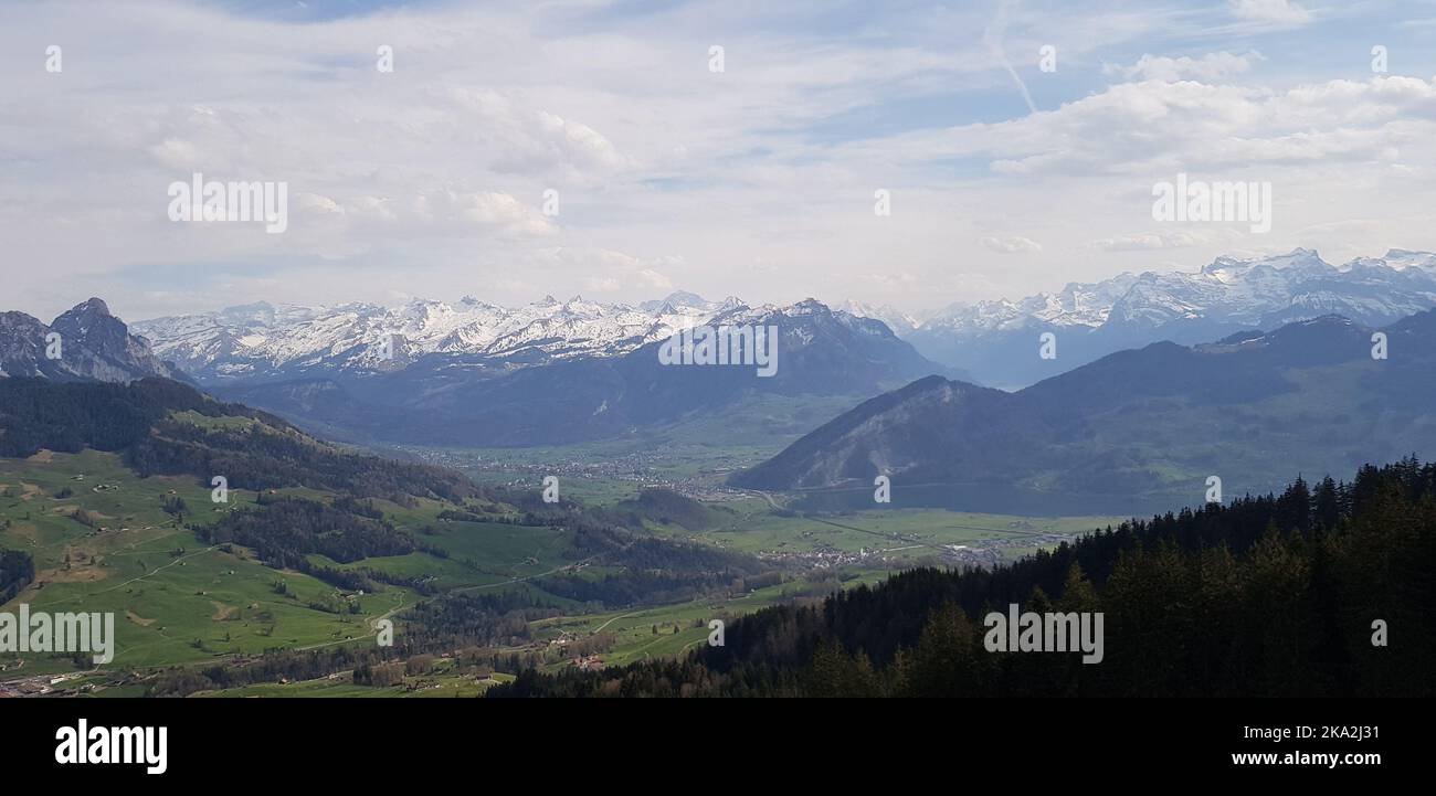 A beautiful scenery of green valley with mountains under cloudy sky ...