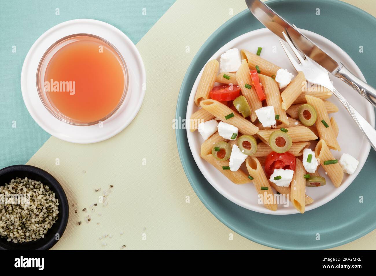 Red lentil penne salad with hempseeds and fruit juice Stock Photo