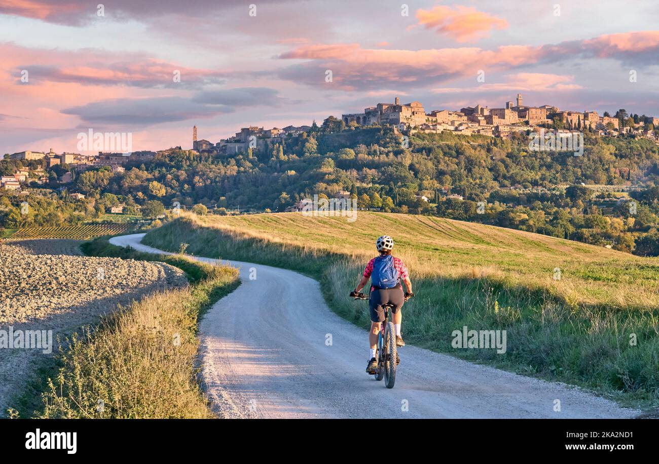 nice senior woman riding her electric mountain bike between olive trees