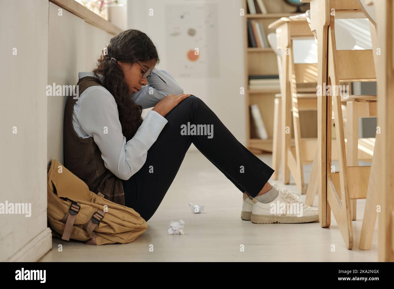 Girl feeling sad and lonely while sitting on the floor alone Stock