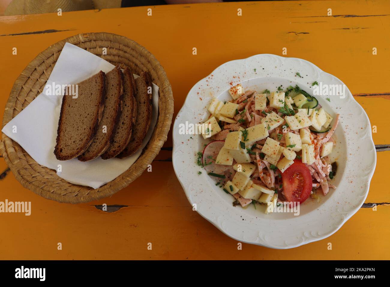 Schweizer Wurstsalat mit Brot, platziert auf einem typischen bayerischen Biertisch als Brotzeit im Biergarten in Bayern und Franken Stock Photo