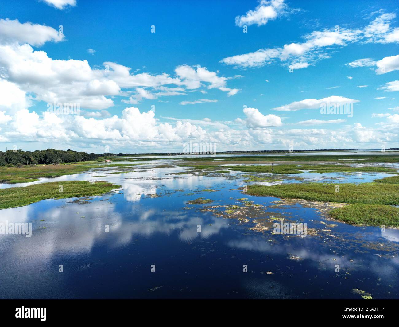 A cloudy sky reflected in a blue lake Stock Photo - Alamy