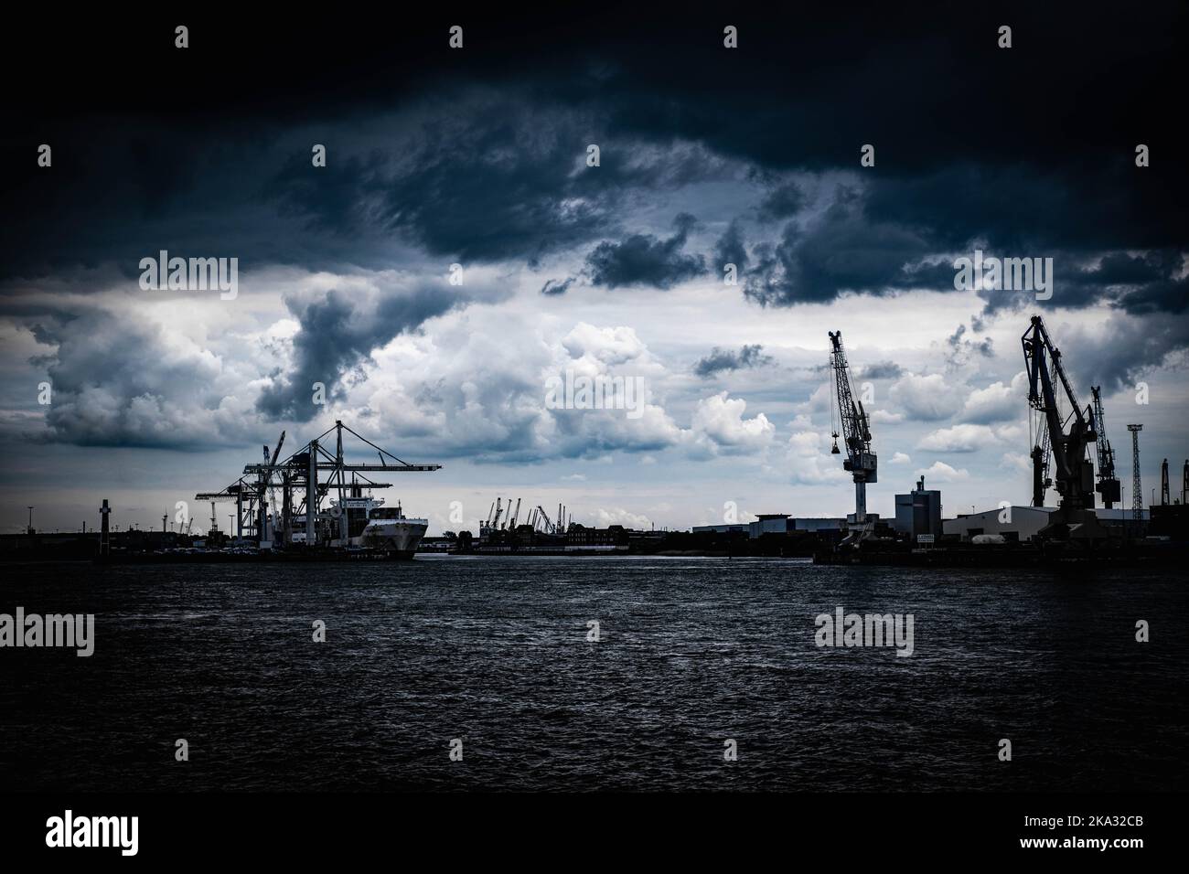 The view of the cranes against the dark cloudy sky Stock Photo - Alamy