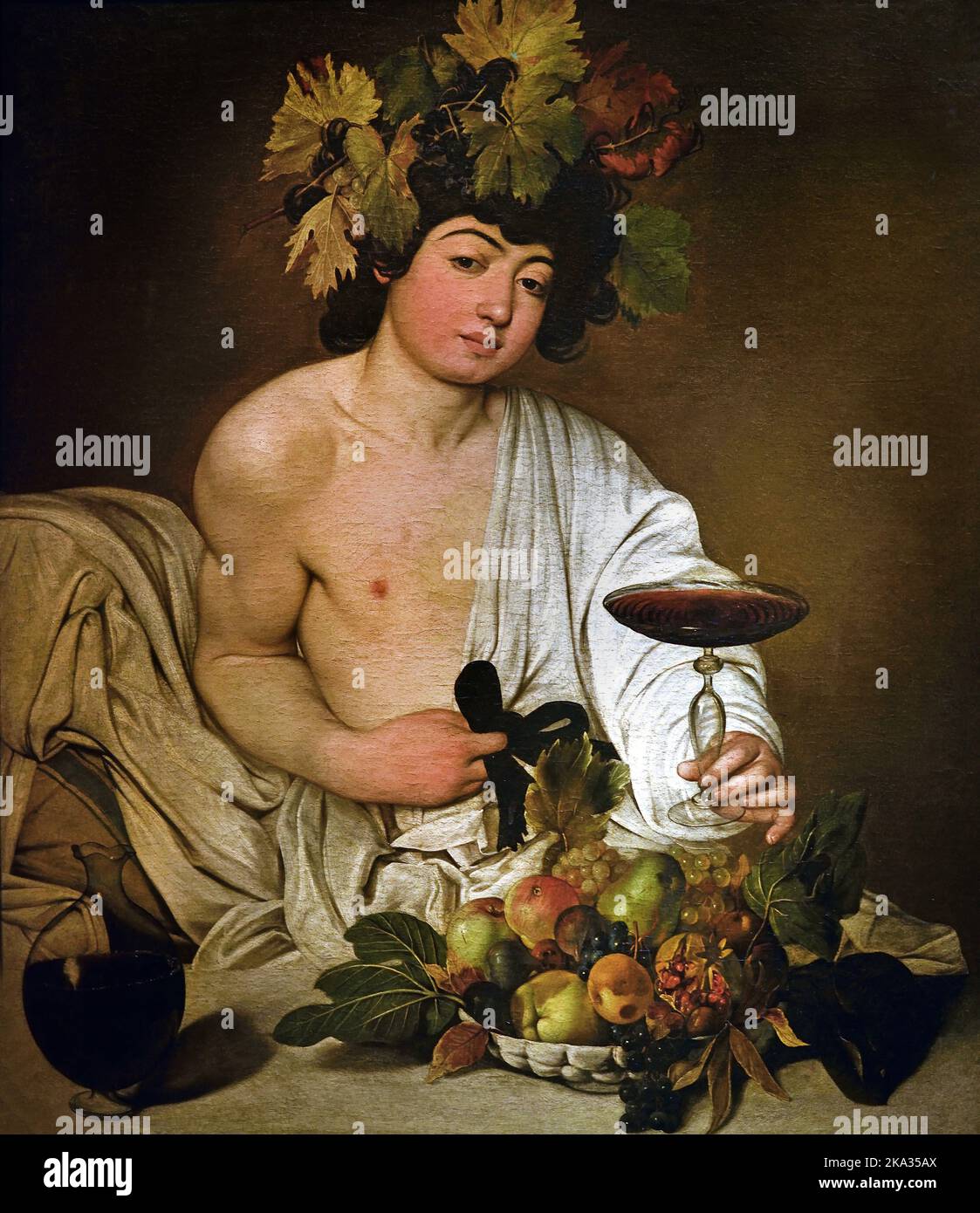 Bacchus, by  Michelangelo Merisi, known as Caravaggio (Milano 1571 - Porto Ercole 1610) , Florence, Italy. ( His depiction of the basket of fruit and the cup of wine proffered by the god is surprising, with such elements interpreted by some critics as a Horatian invitation to frugality, conviviality and friendship. ) Stock Photo
