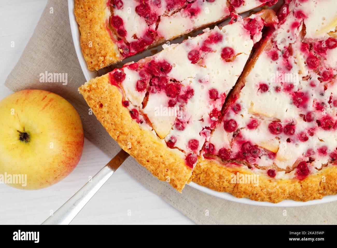 Closeup homemade apple and redcurrant pie on white wooden table. Top view. Stock Photo