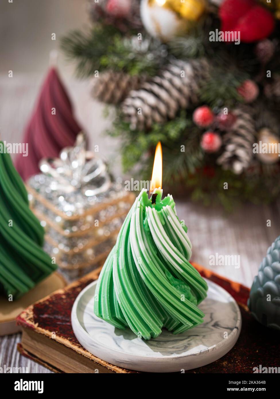 Christmas Candle. New Year's composition with candle in the shape of a Christmas tree. Burning wax candle in shape of fir tree with. Copy space Stock Photo