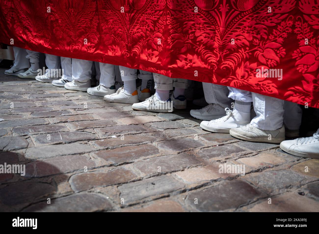 The feet of people carrying a heavy throne  in an Easter Parade during Holy week or semana santa in Cadiz, Spain Stock Photo