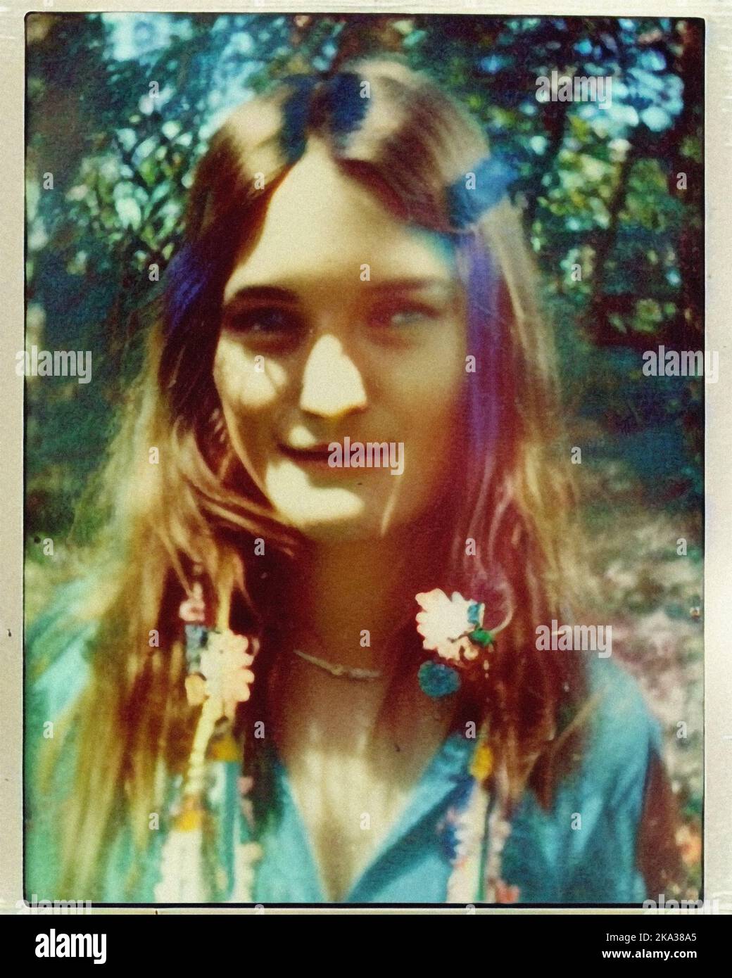A young hippie woman with flowers in her hair, vintage retro Polaroid Stock Photo