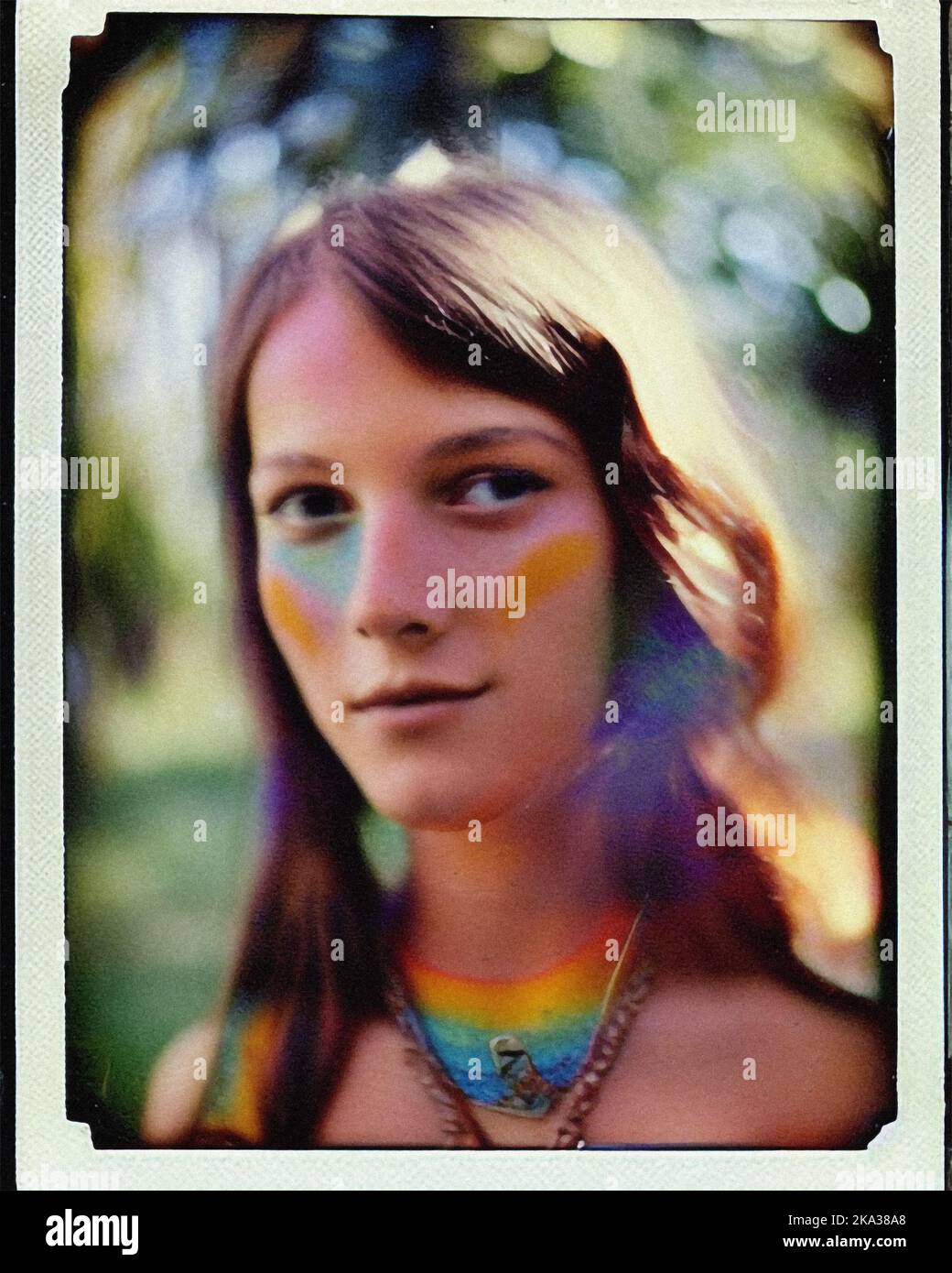 A young hippie woman with rainbow face paint, vintage retro Polaroid Stock Photo