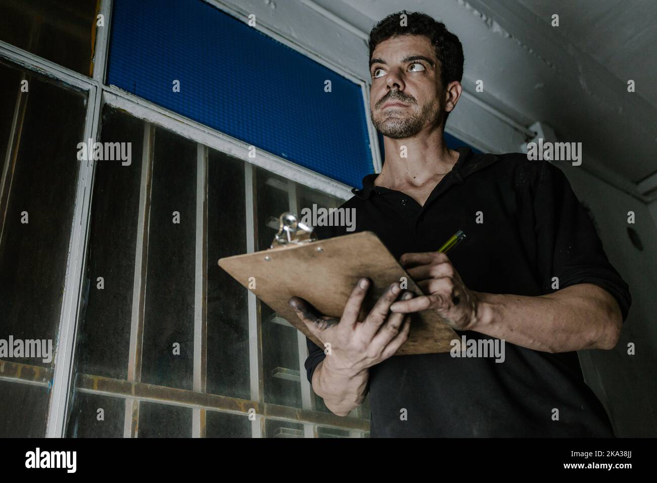 Technician checking paperwork in car service station Stock Photo