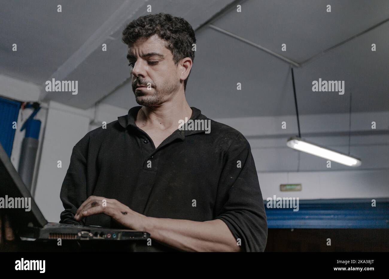 Car mechanic working on laptop in workshop Stock Photo