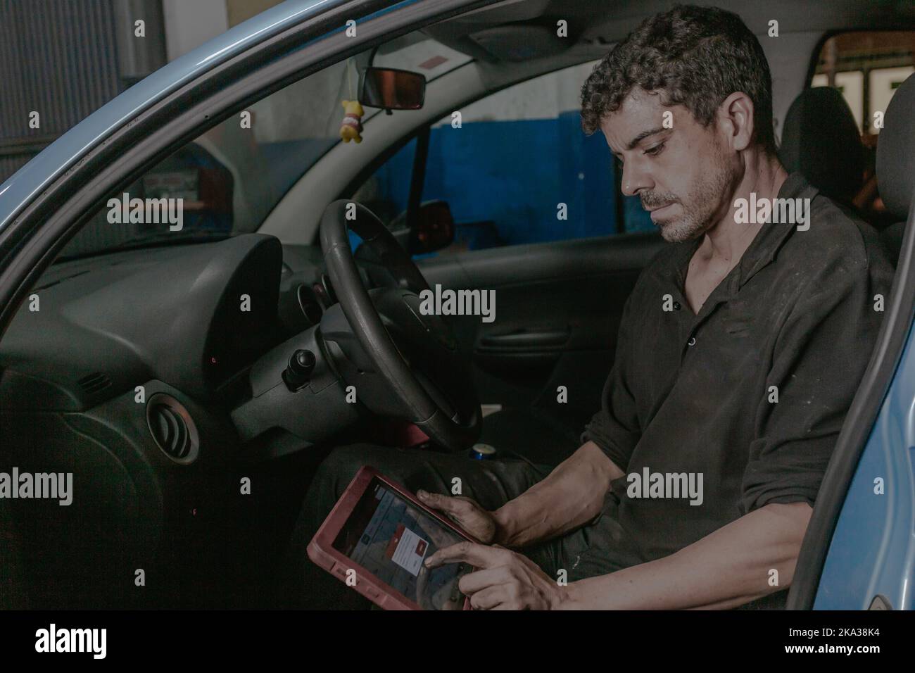 Mechanic using laptop in car Stock Photo
