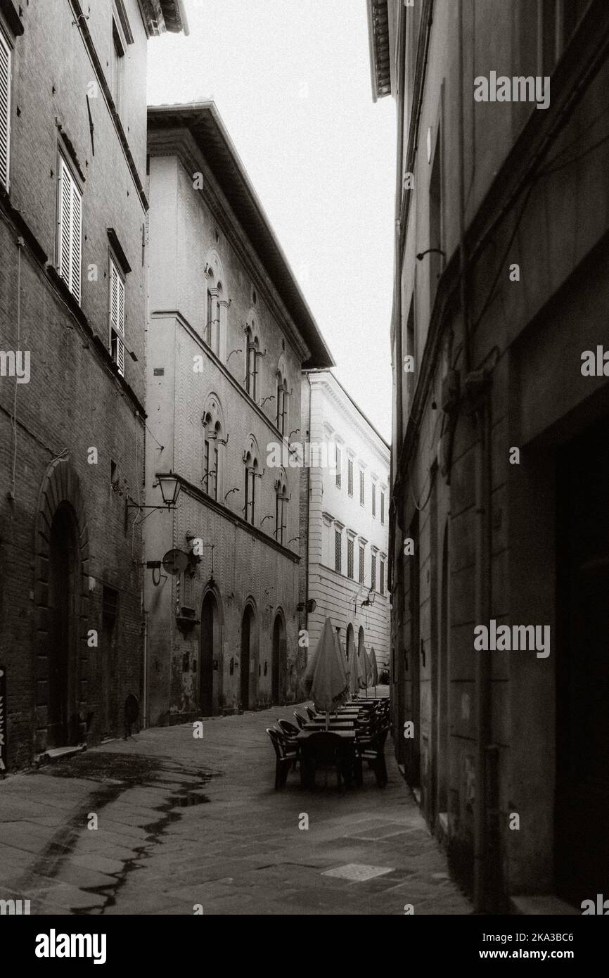 A vertical closeup of a narrow alleyway between high buildings in ...