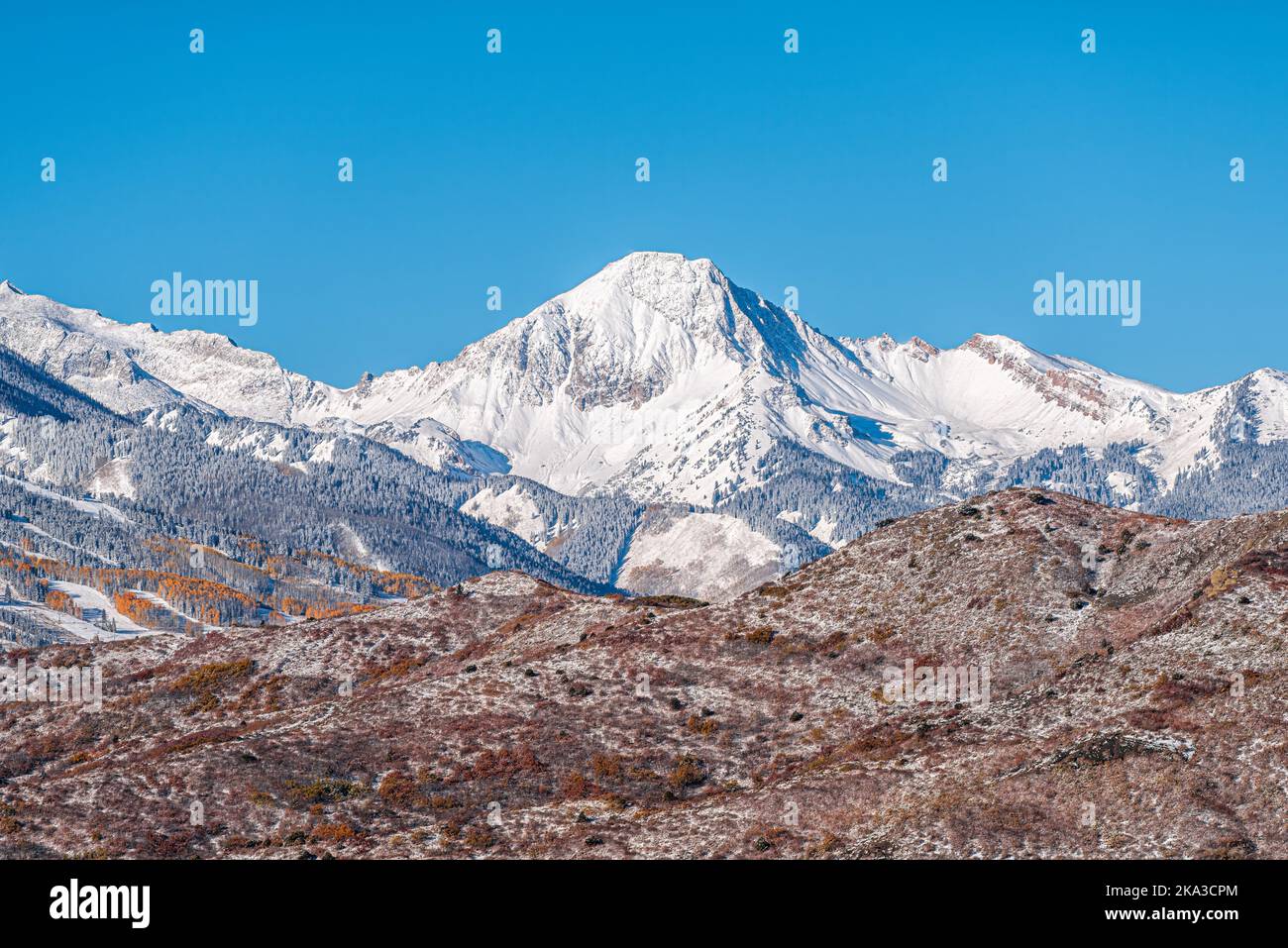 Aspen, Colorado with blue clear sky by Capitol Mt Daly Snowmass mountain peak ridge closeup in autumn fall season covered in winter snow Stock Photo
