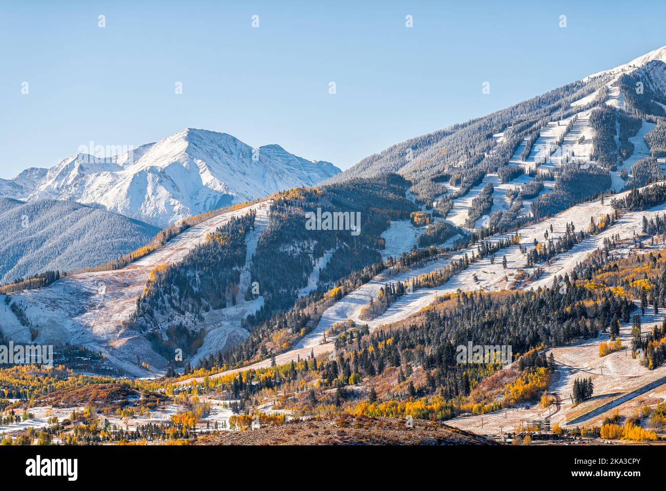 Aspen, Colorado buttermilk ski resort town slopes hill in Rocky mountains view on sunny day with winter snow on yellow foliage autumn trees Stock Photo