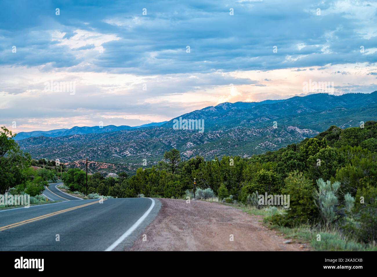Sangre De Cristo mountains sunset on Bishops Lodge Road street in Santa Fe, New Mexico with pink sunlight by Tesuque residential community Stock Photo