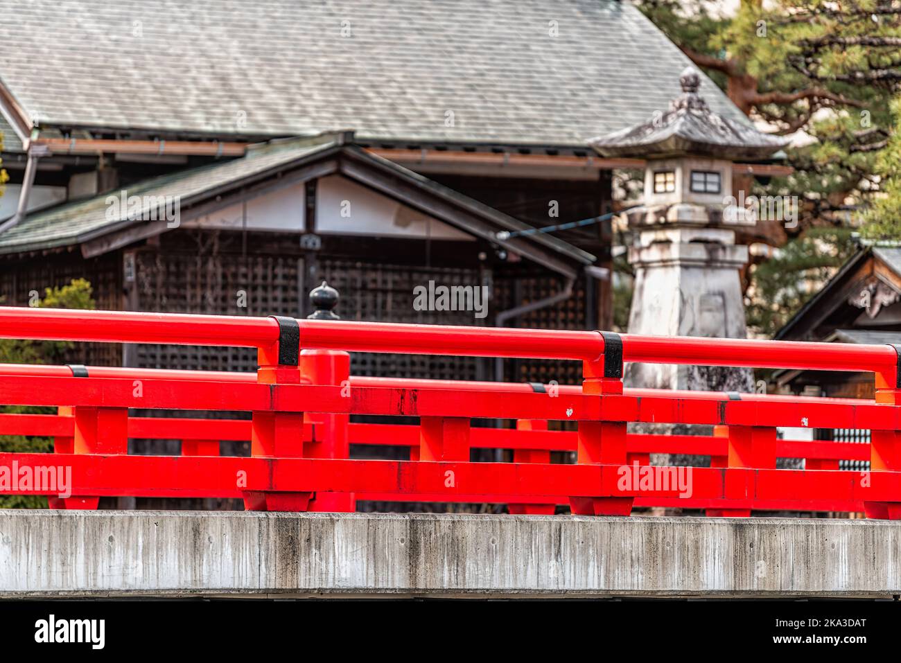 Red vermilion color bridge railing over Enako river Stone paved path footpath in Takayama, Japan at Higashiyama walking course in historic city of Gif Stock Photo