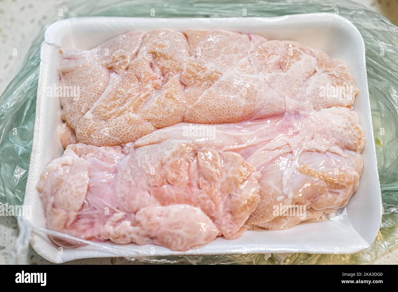 Macro closeup of fresh whole beef sweetbreads thymus organ gland, nutritious ancestral meat food in plastic wrap bag Stock Photo