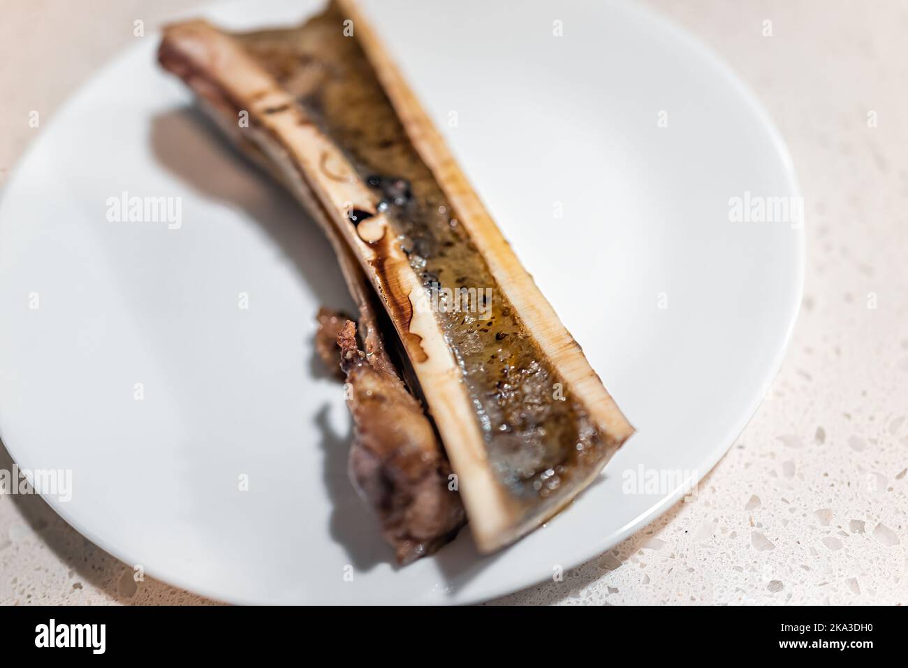 Macro closeup of one half of baked cooked marrow beef bone split in