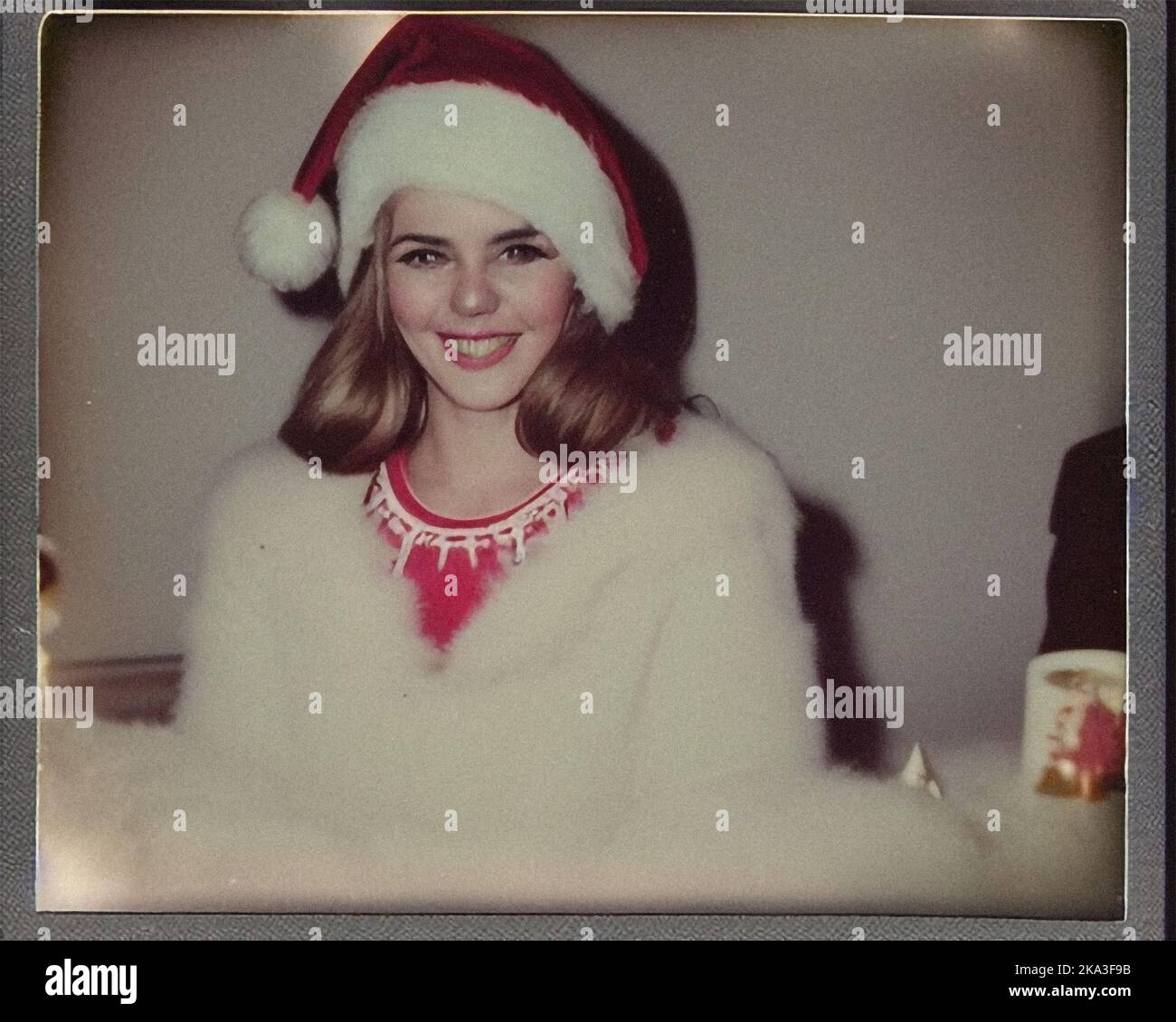 A beautiful young woman dressed for Christmas, retro vintage Polaroid Stock Photo