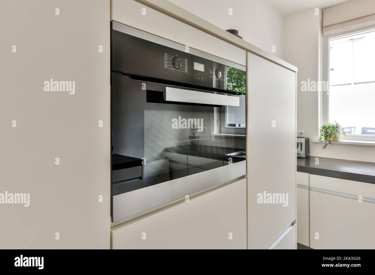 Interior of kitchen with contemporary built in stove and cabinets near ...