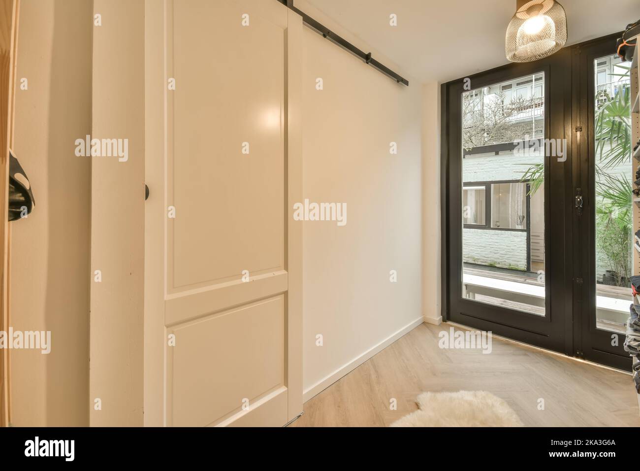 Interior of corridor with white walls and glass entrance doors in modern big house Stock Photo