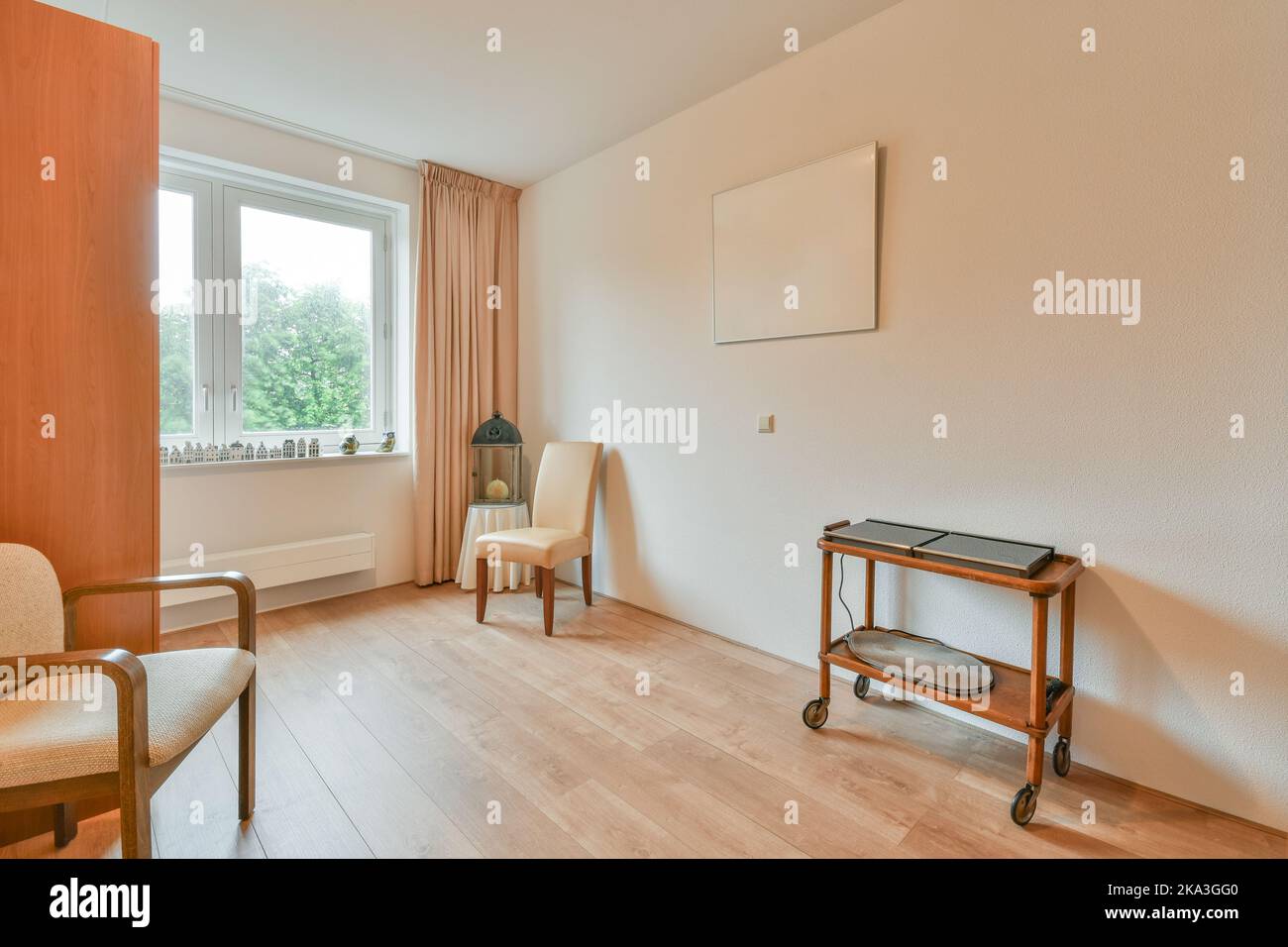 Bright room with a table and chairs next to a bright window Stock Photo ...