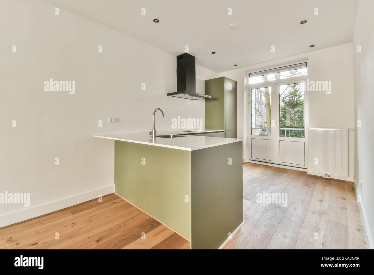 Spacious empty kitchen with white walls and laminate floor in modern ...