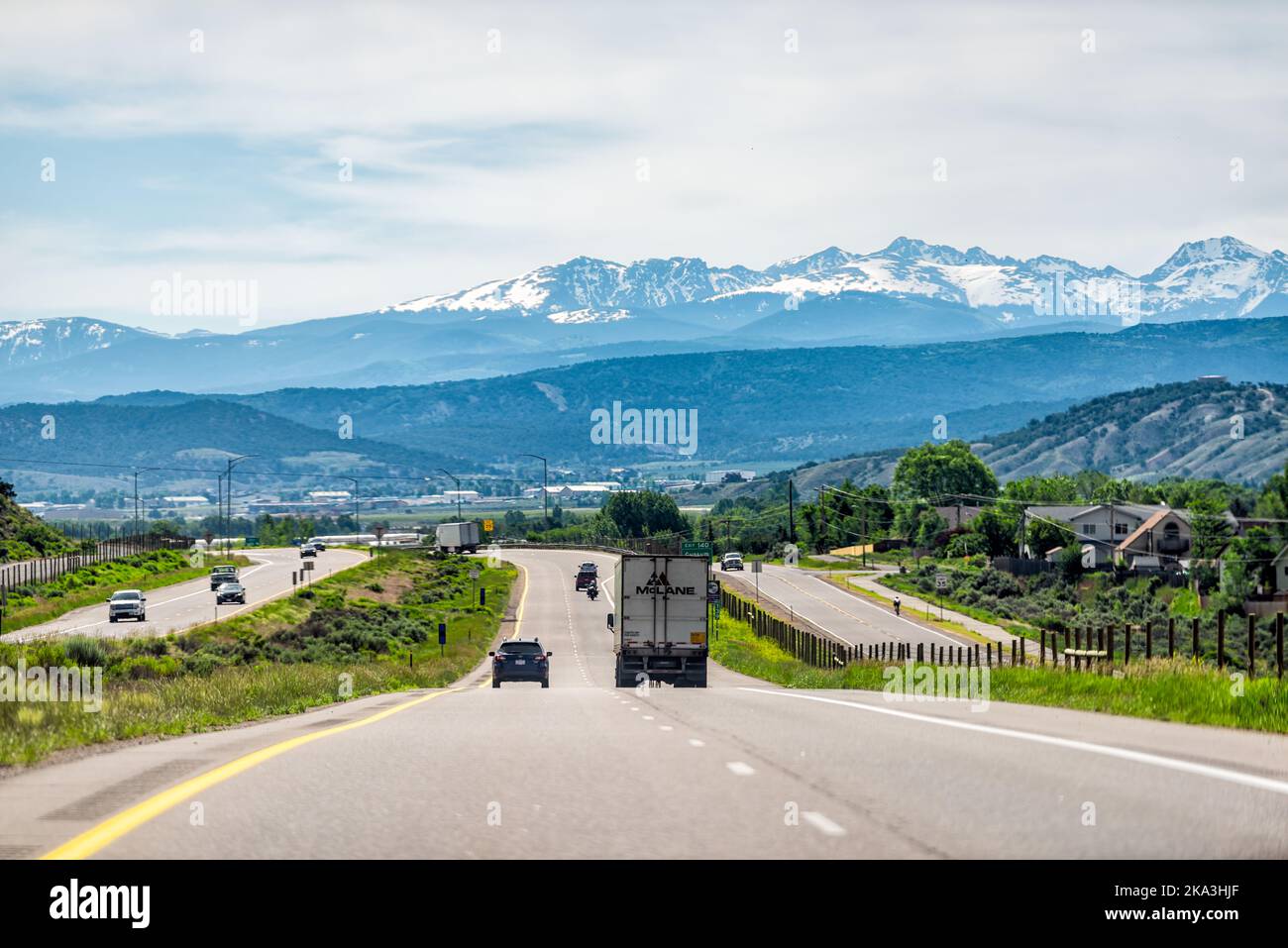 Gypsum, USA - June 29, 2019: Interstate i70 highway through Colorado's Western Slope with cars in traffic and driving point of view of snowcapped rock Stock Photo