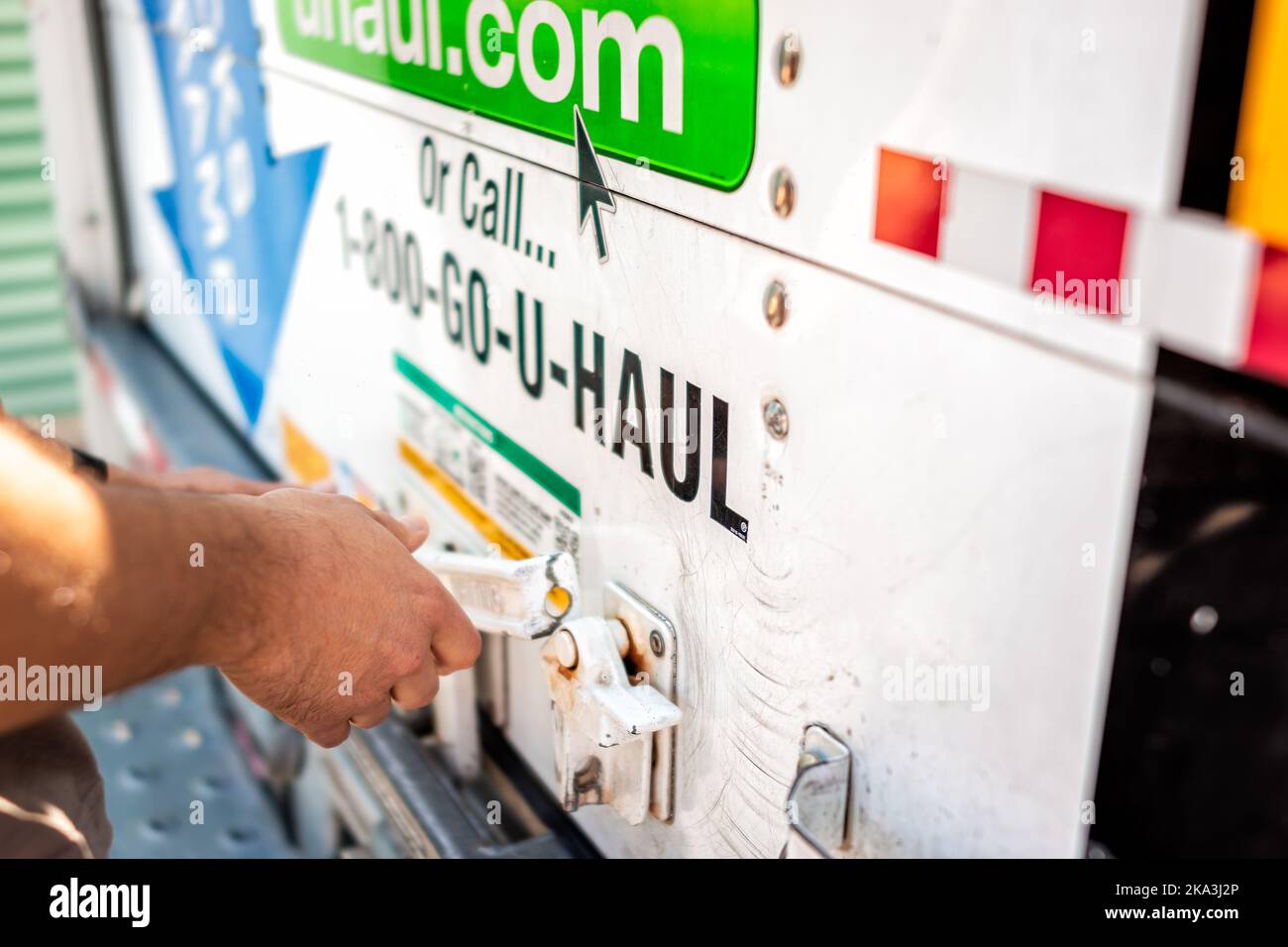 Ft Myers, USA - May 16, 2022: Closeup of man hand locking closing door of U-haul cargo truck trailer vehicle for move, moving relocation from Florida Stock Photo