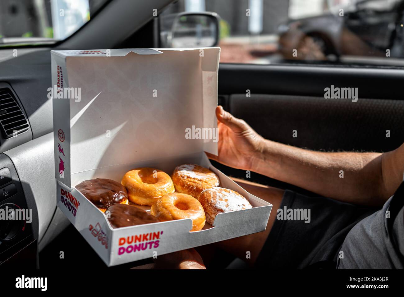 Naples, USA October 27, 2021 Man holding Half a dozen of Dunkin