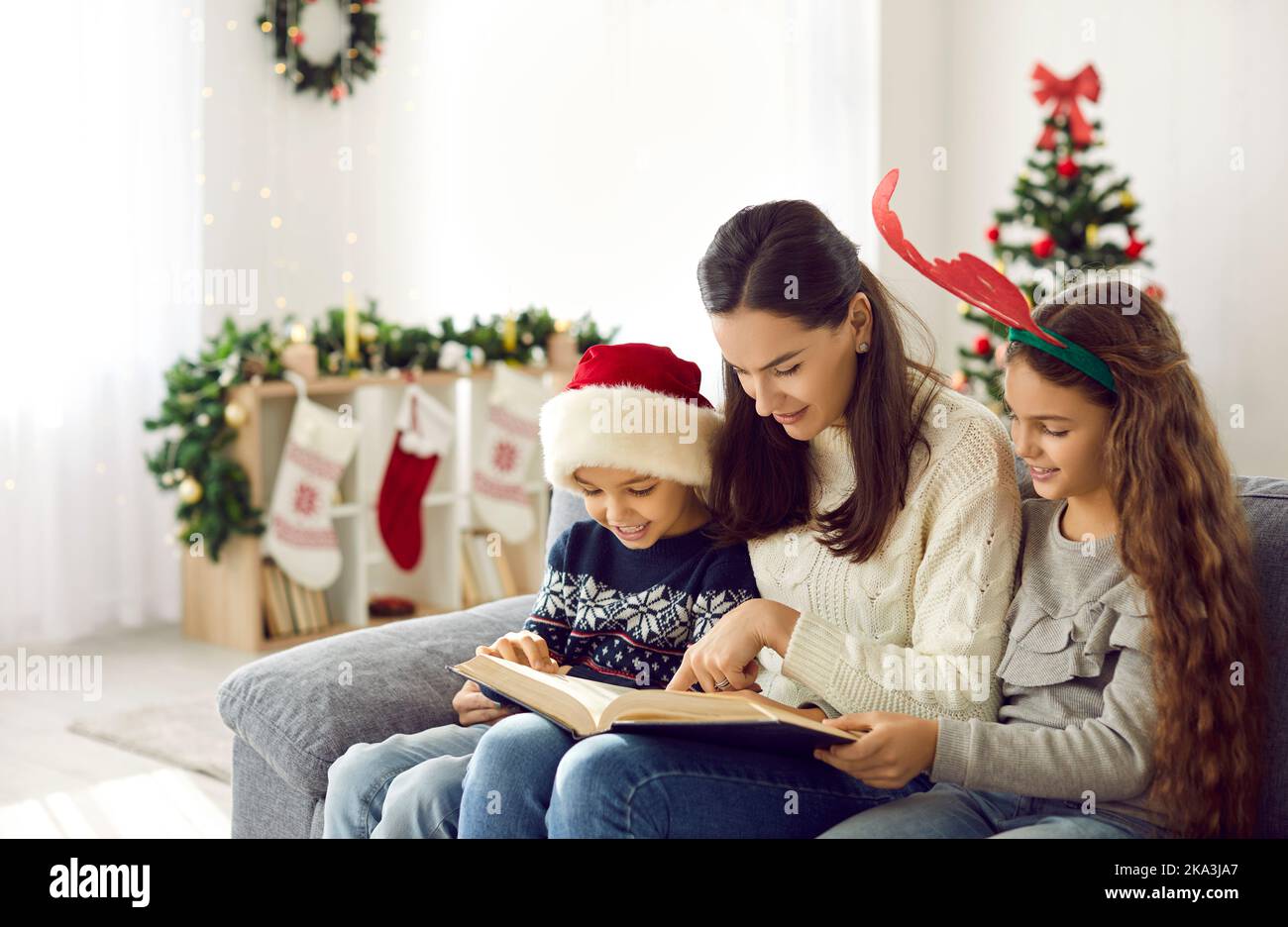 Loving mom read book with kids on winter holidays Stock Photo