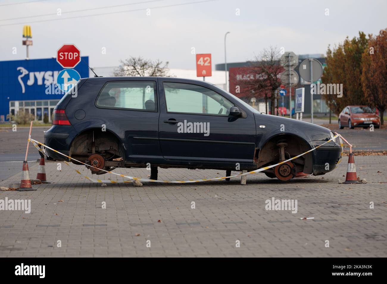 Poland, Poznan - October 30, 2022: A car without wheels parked in a store parking lot. The thieves replaced the wheels with stones. Vandalism. Stock Photo