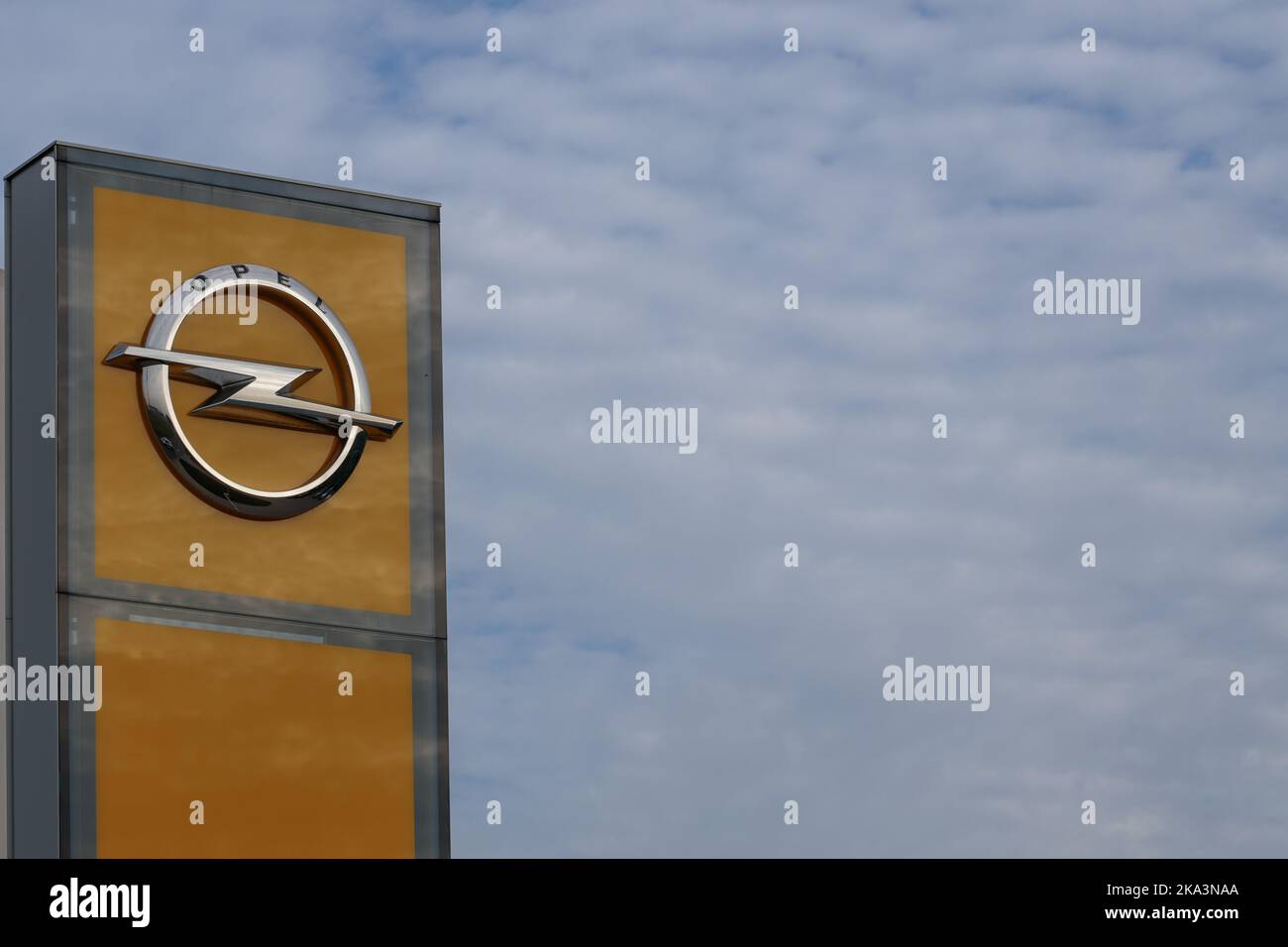 Poland, Poznan - October 30, 2022: Opel logo outside the car showroom area, against a blue sky with clouds. It is the symbol of the German internation Stock Photo