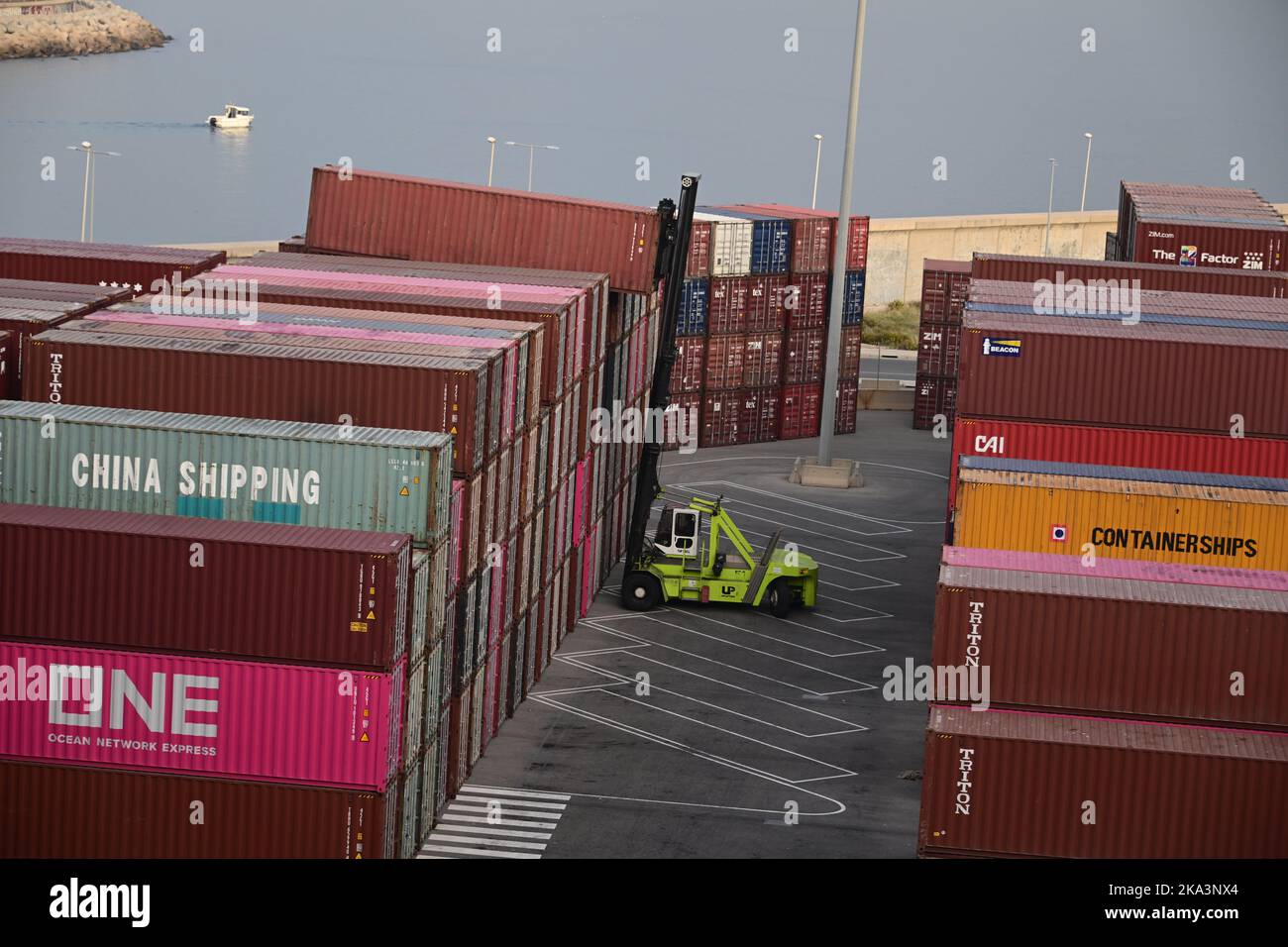 A crane mobile crane lowers a shipping container into a set with other ...