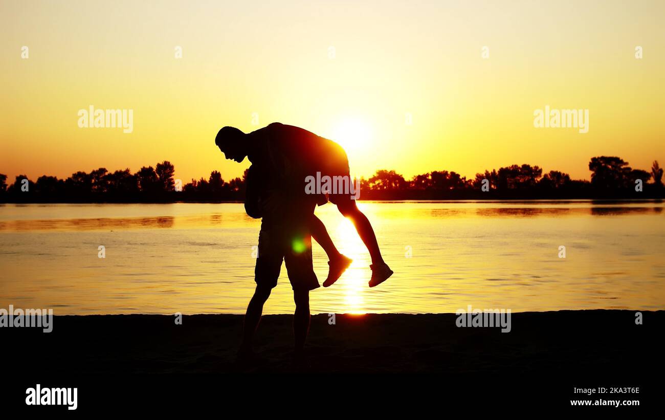 Two dark male figures, at sunrise, against the light, boxing, fighting