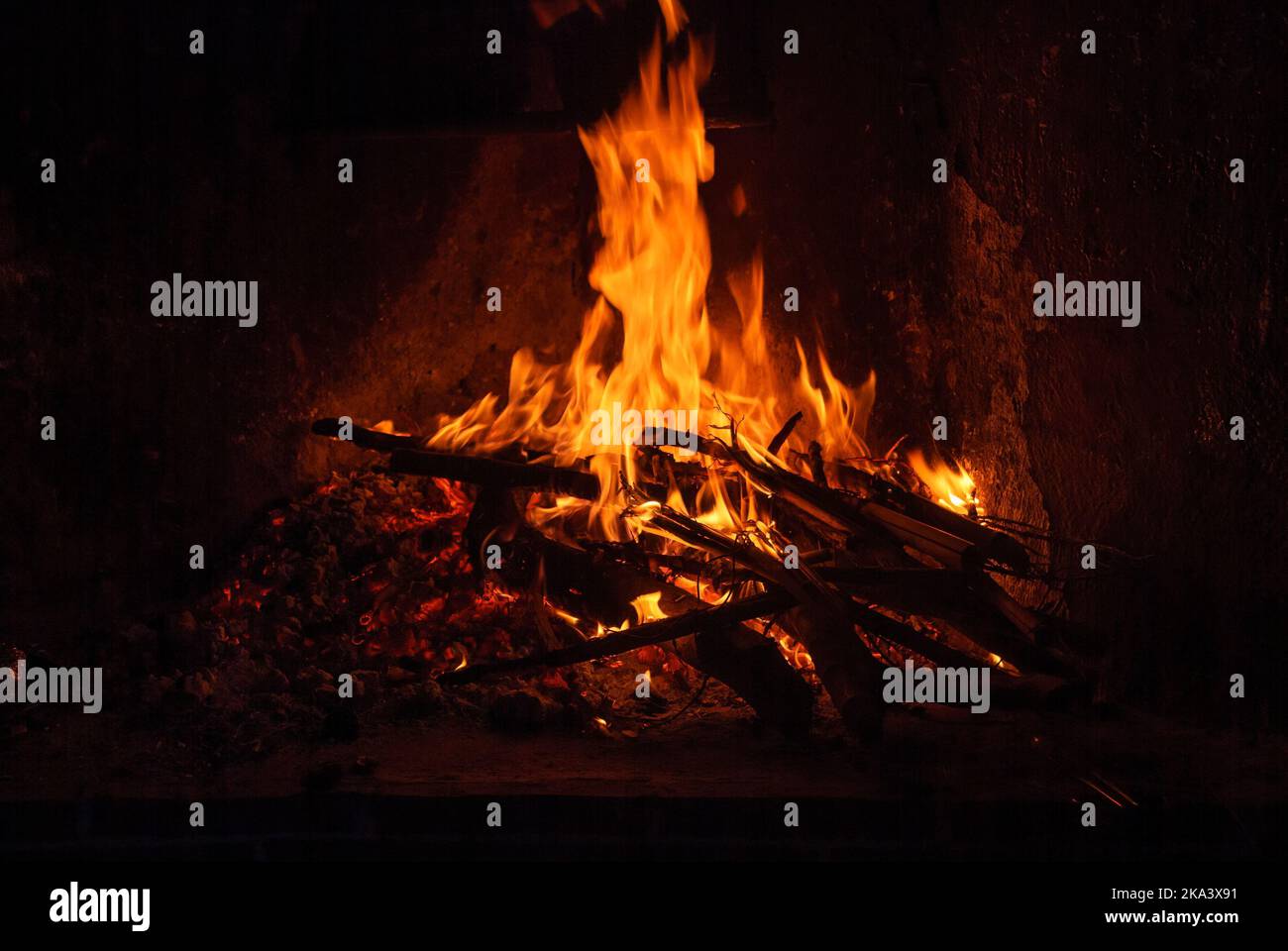 Firewood burning in corner of house, warmth of home and hypnotic image. Stock Photo