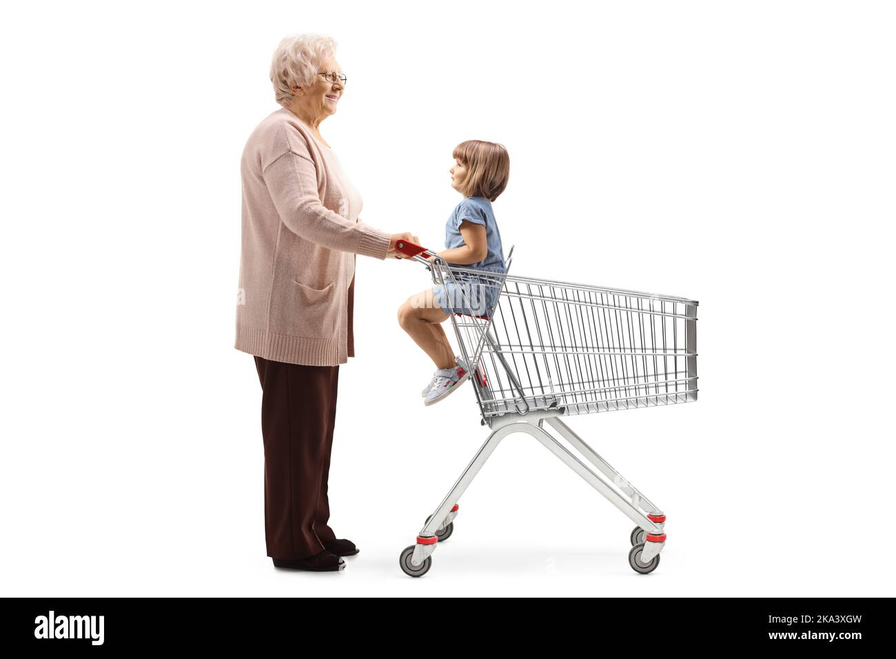Full length profile shot of grandmother with a child in a shopping cart