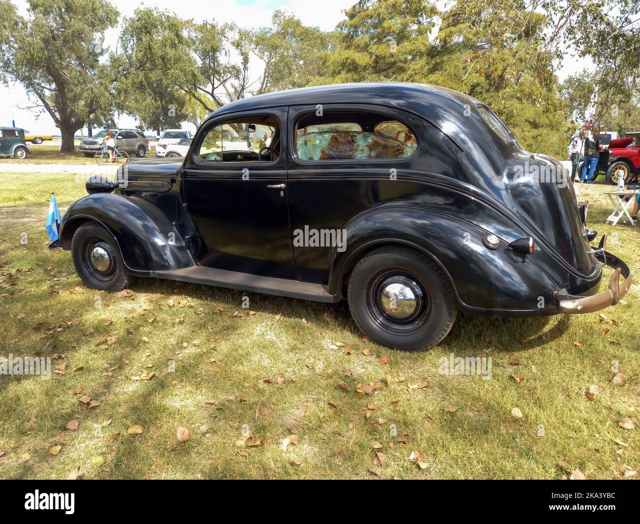 Old black Plymouth two door fastback sedan circa 1937 parked in the countryside. Side view. Nature grass and trees. Front view. Classic car show Stock Photo