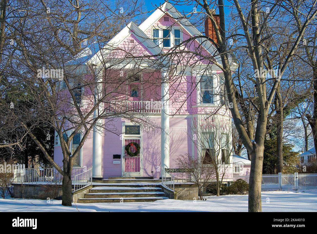 Pink Victorian house with green Christmas wreath on front door Stock Photo