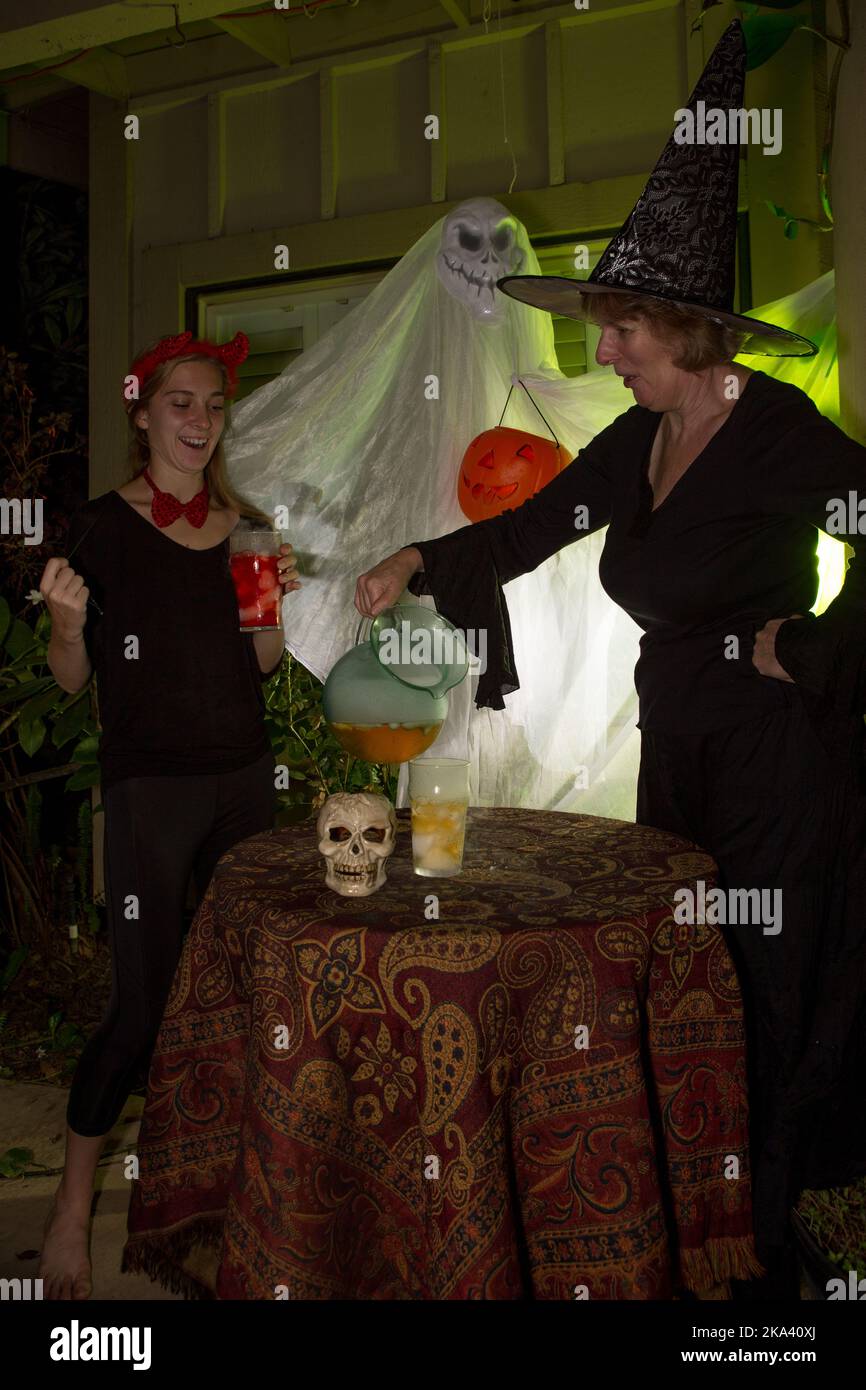 Halloween Witches mixing drinks at a halloween house party. Stock Photo