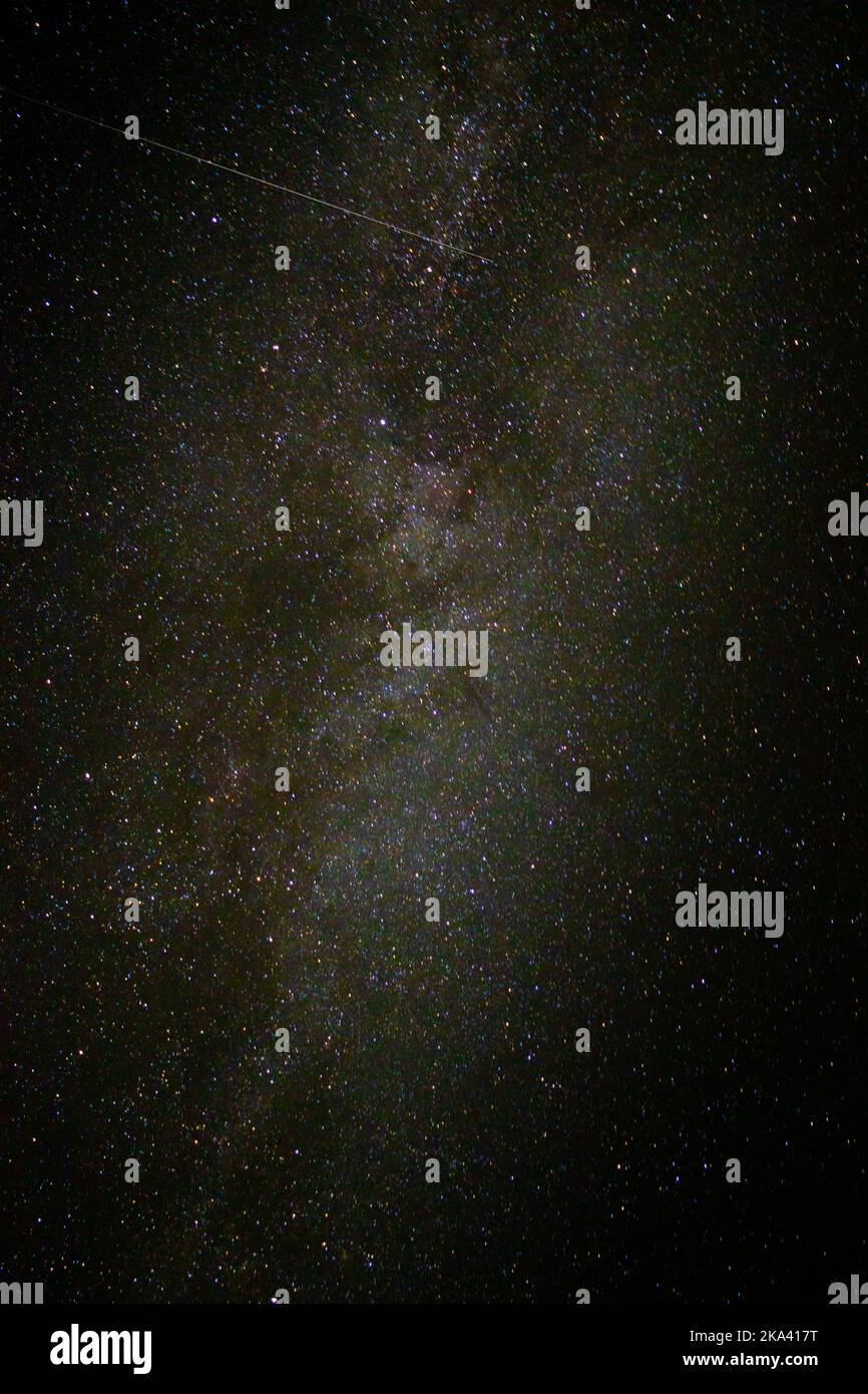 A vertical shot of the Milky Way galaxy with shiny stars in the night ...