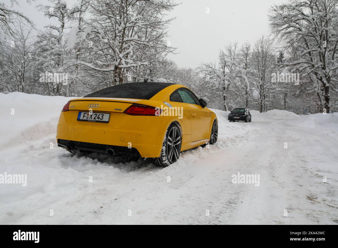 https://c8.alamy.com/comp/2KA42MC/a-yellow-audi-tt-driving-through-snowy-road-with-a-car-spun-out-in-front-of-it-2KA42MC.jpg