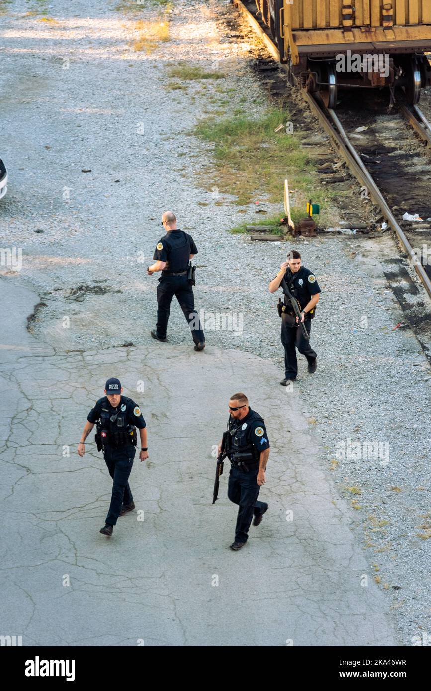 Metro police respond to a reported crime, guns drawn, searching by the railroad tracks for a suspect in downtown Nashville, Tennessee. Stock Photo