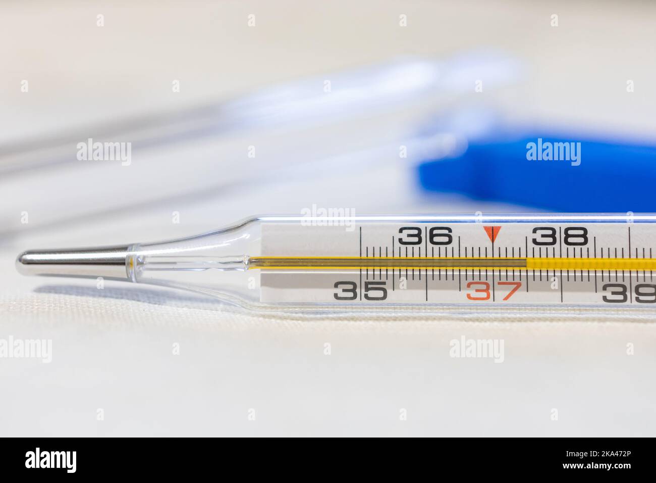 A closeup of an analogue thermometer signed 37,5 degrees so it's fever