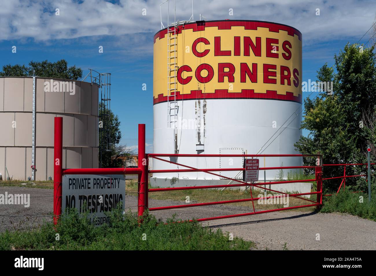 A large tank, the upper half painted with red and yellow with the words Cline Corners in large block letters, Clines Corners, New Mexico. Stock Photo