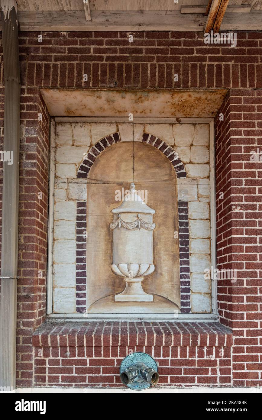 A painting of an urn-like vase in an inset in the brick wall of the abandoned theater in Pine Bluff, Jefferson County, Arkansas. Stock Photo
