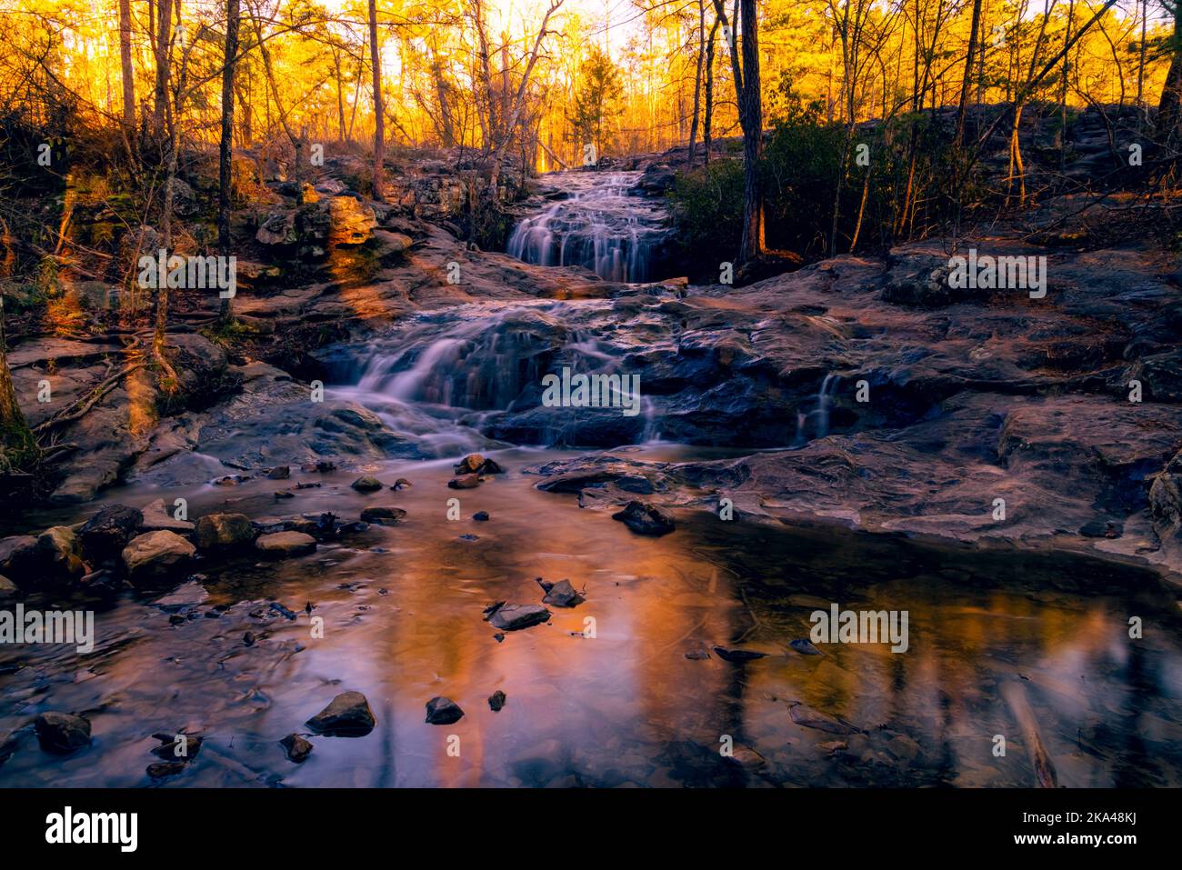A beautiful natural scenery with a waterfall flowing down the rocks in ...